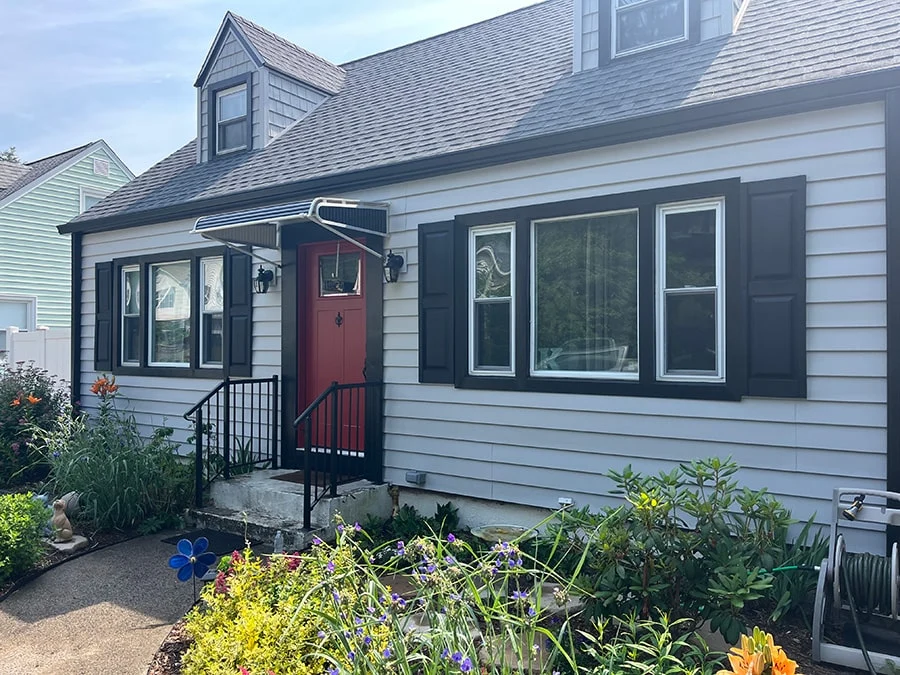 black aluminum door canopy above a red entry door